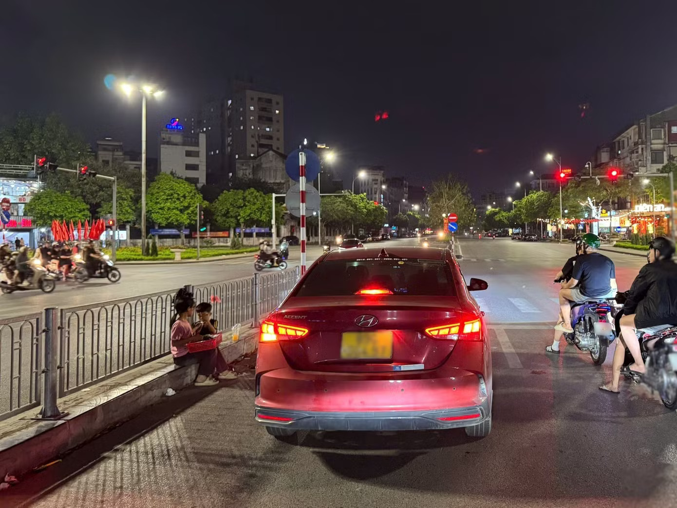 Trẻ em bán hàng rong dưới lòng đường tại nút giao Nguyễn Văn Huyên - Nguyễn Khánh Toàn. (Ảnh: Đức Hiếu) Người bán hàng tràn xuống ngã tư ở Hà Nội, nguy cơ tai nạn rình rập - Ảnh 6.