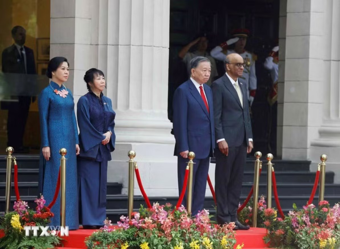 Tổng Bí thư, Chủ tịch nước Tô Lâm và Tổng thống Singapore Tharman Shanmugaratnam trên bục danh dự, nghe Quân nhạc cử Quốc thiều hai nước. (Ảnh: Thống Nhất/TTXVN) Lễ đón trọng thể Tổng Bí thư, Chủ tịch nước Tô Lâm và Phu nhân tại Singapore - Ảnh 3.
