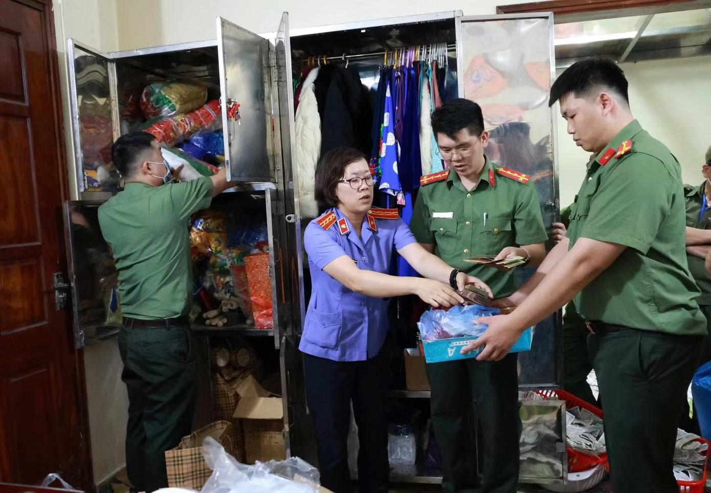 Cơ tố tụng thi hành lệnh khám xét với các bị can. Ảnh: Công an cung cấp. Biển thủ tiền công đức, thủ nhang Đền Kỳ Cùng bị khởi tố - Ảnh 2.
