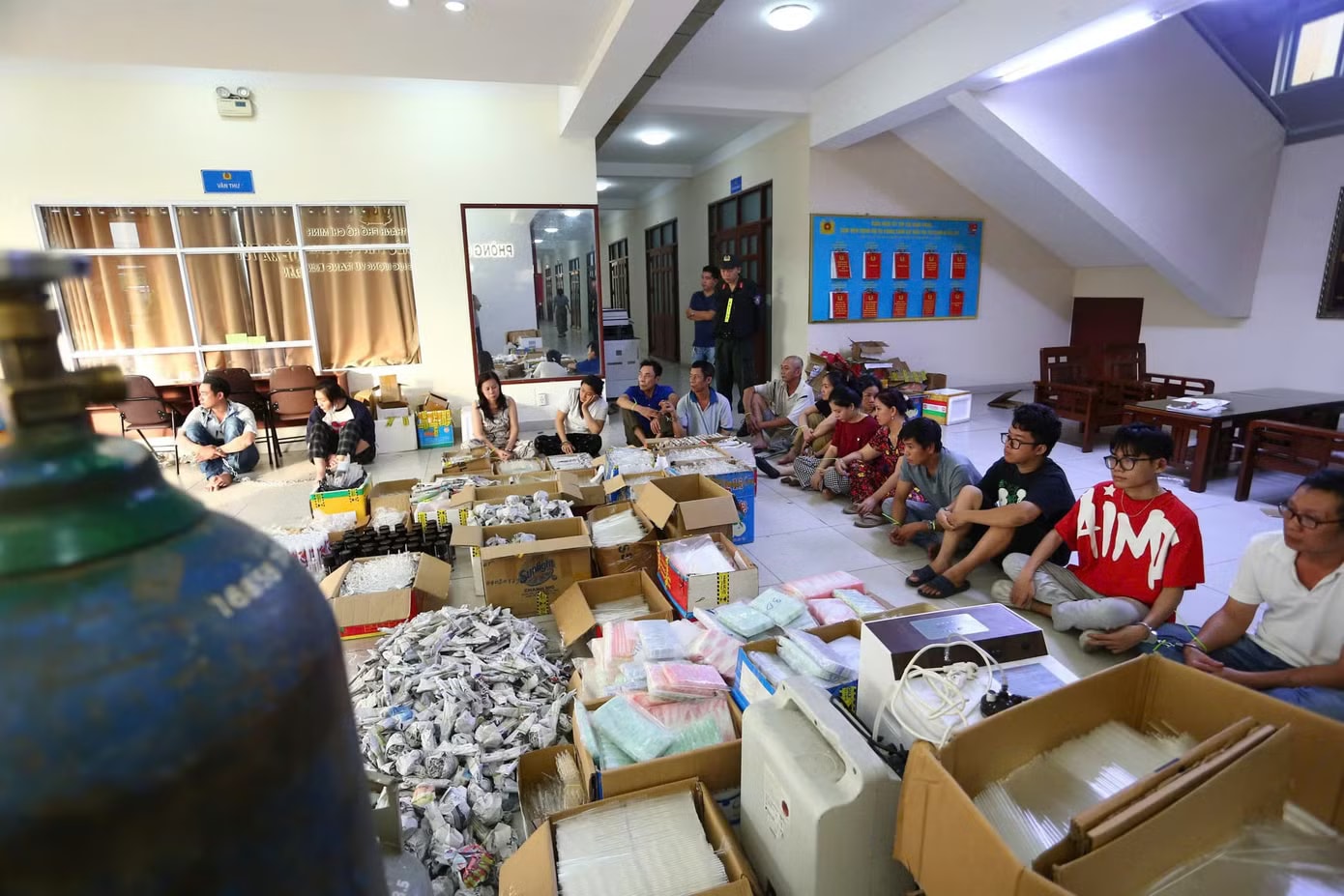 Các đối tượng cùng tang vật bị công an bắt giữ. Đánh sập xưởng sản xuất dụng cụ phục vụ sử dụng ma túy quy mô ‘khủng’ - Ảnh 1.