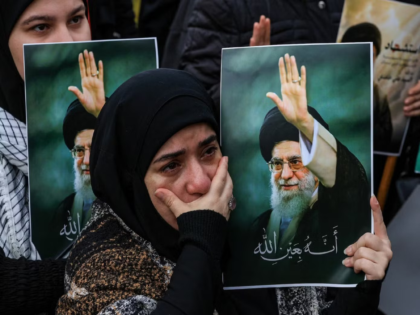 Một phụ nữ cầm bức ảnh chân dung của Đại giáo chủ Ali Khamenei. (Ảnh: Reuters) Iran chuẩn bị tang lễ cố Lãnh tụ Tối cao Ali Khamenei - Ảnh 1.