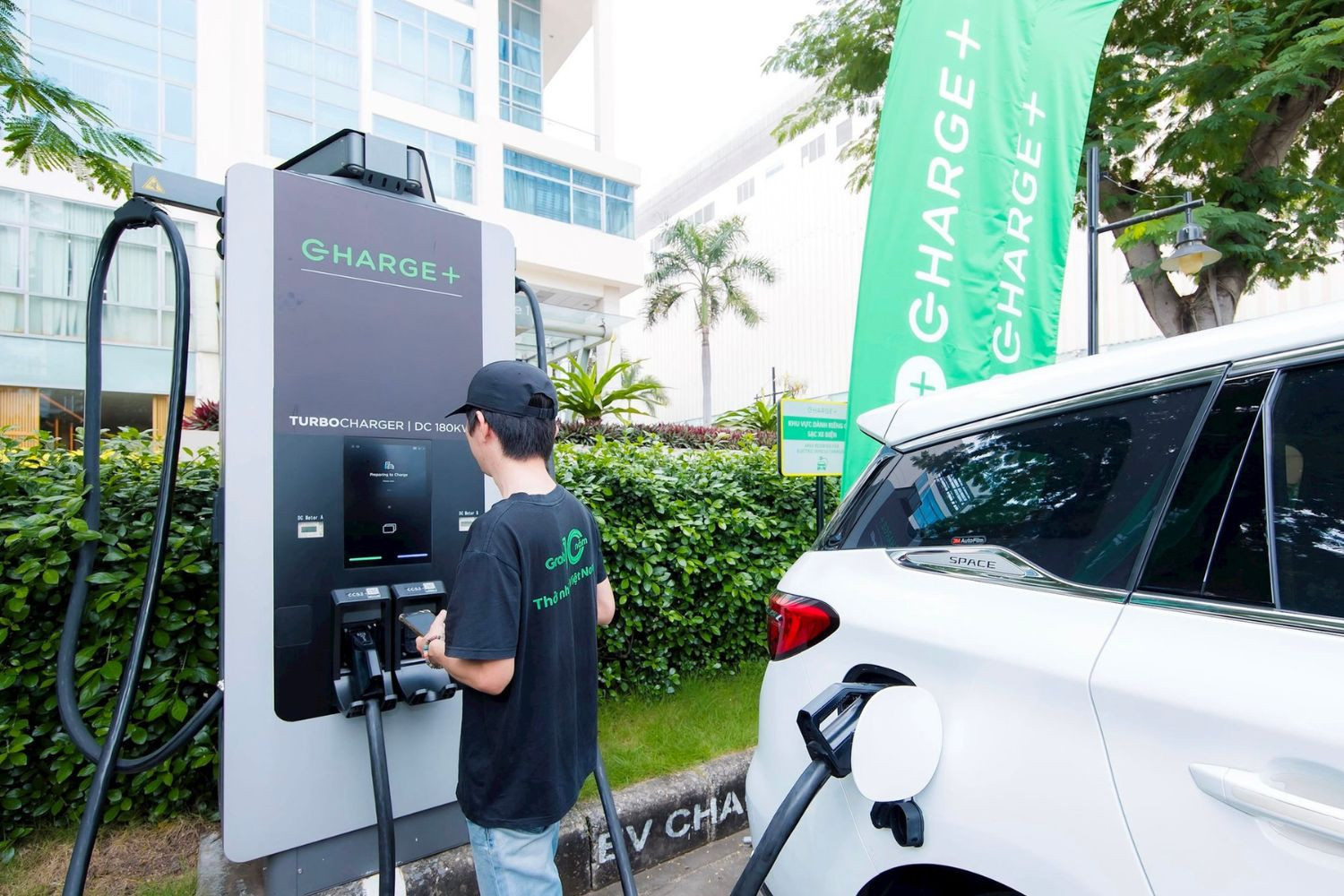 Chủ xe sạc điện tại một trạm sạc