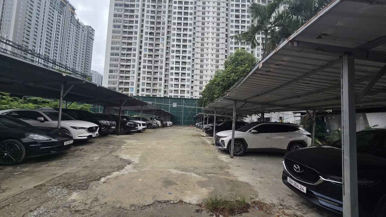 Một phần lớn diện tích tại đây đã bị biến tướng thành bãi trông giữ xe quy mô lớn. Toàn bộ khu vực này được quây tôn, dựng mái che bán kiên cố nhằm phục vụ lượng phương tiện lớn từ các khu vực lân cận đổ về. Khu 'đất vàng' biến tướng thành bãi gửi xe và chợ cóc - Ảnh 3.