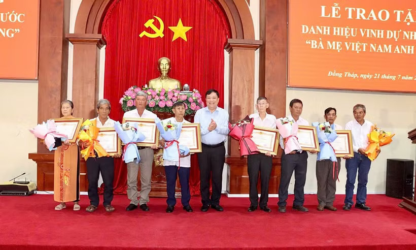 Chủ tịch Ủy ban Nhân dân tỉnh Phạm Thành Ngại trao Bằng công nhận và hoa cho thân nhân các mẹ Việt Nam anh hùng. (Nguồn: Cổng thông tin điện tử Đồng Tháp)