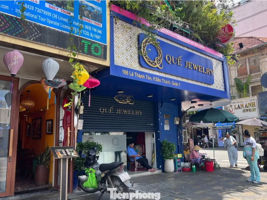 Mặt tiền khác của tiệm kim cương Quế Jewelry cửa chỉ mở hờ, bảo vệ ngồi bên trong khi thấy có khách sẽ thông báo cửa hàng tạm nghỉ. Tiệm kim cương này thông báo tạm nghỉ đến ngày 3/8 để sắp xếp lại hoạt động và chuẩn bị tốt hơn cho chặng đường sắp tới. Nơi này cũng hứa hẹn Đóng cửa hàng loạt, nhiều tiệm kim cương ở TPHCM đổ lỗi cho khách hàng - Ảnh 2.