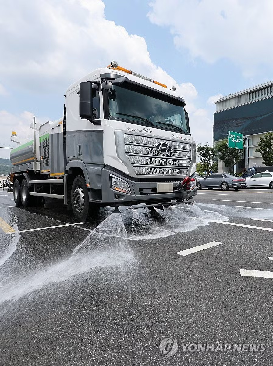 Phun nước xuống đường để hạ nhiệt. (Ảnh: Yonhap) 19 người chết do nắng nóng ở Hàn Quốc, tổng thống ra chỉ thị khẩn - Ảnh 2.