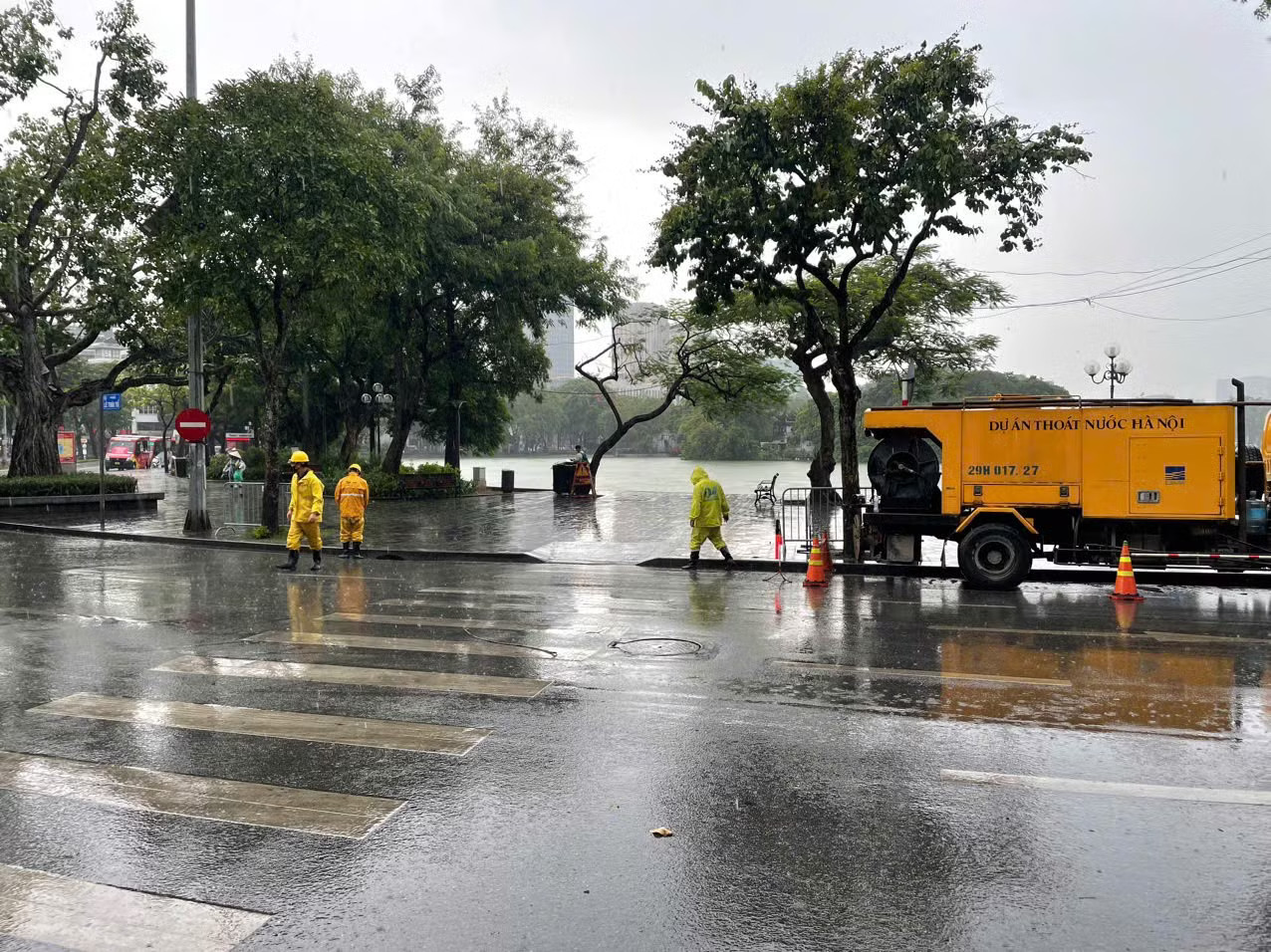 Lực lượng công nhân và phương tiện chuyên dụng túc trực tại các điểm trọng yếu trên địa bàn Hà Nội để khơi thông dòng chảy, sẵn sàng xử lý các tình huống ngập úng. Hà Nội nhiều nơi mưa rất to, chưa ghi nhận ngập úng - Ảnh 1.