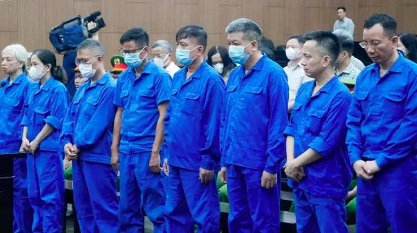 Các bị cáo Nguyễn Bá Hoan và Tống Hải Nam (đứng giữa). Cựu Thứ trưởng Nguyễn Bá Hoan bị tuyên phạt 12 năm tù - Ảnh 2.