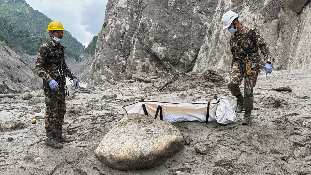 Binh lính Nepal khiêng thi thể công nhân được tìm thấy tại hiện trường dự án thủy điện ở Upper Trishuli ngày 1/9. (Ảnh: AP) Gần 4.000 người vẫn mất tích, nhiều gia đình Nepal làm lễ tang tượng trưng - Ảnh 2.