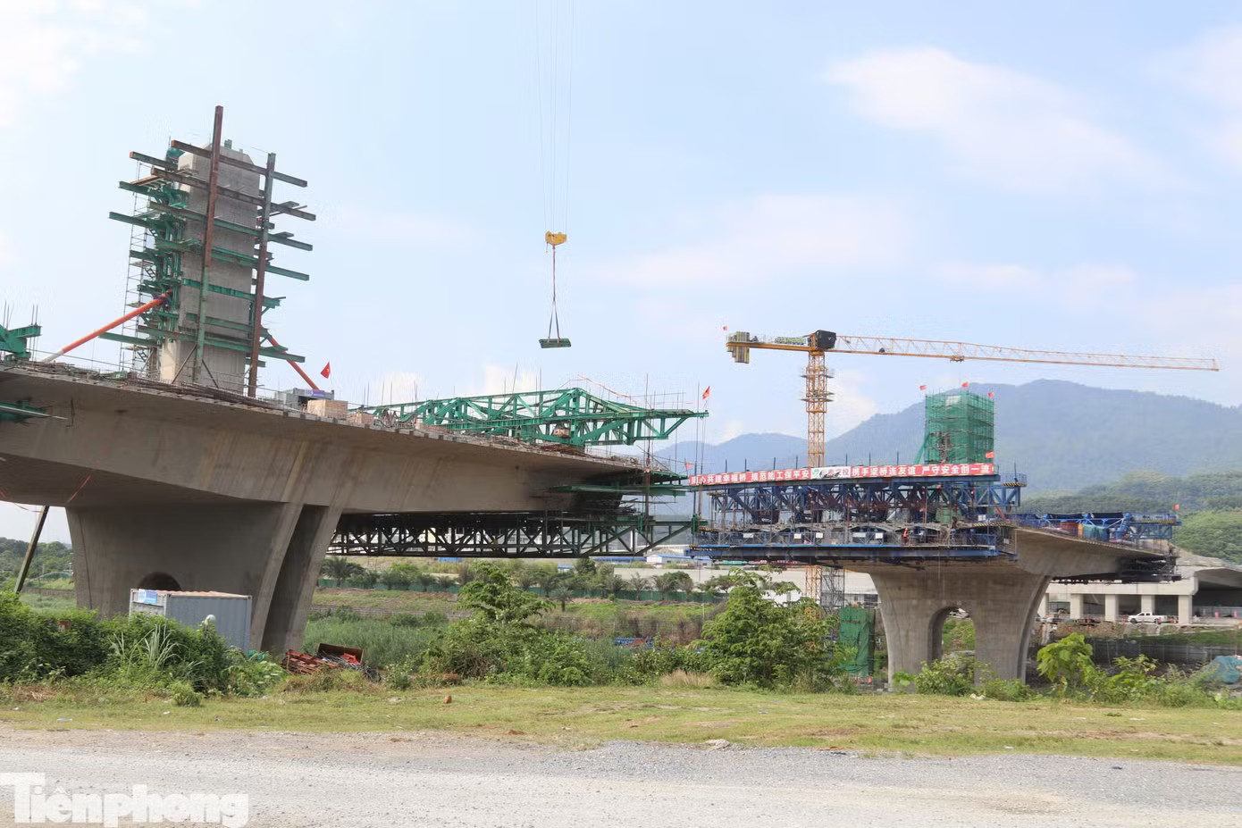 Hiện nhà thầu đã hoàn thành toàn bộ kết cấu phần dưới, gồm mố M2, trụ T8, T9; kết cấu phần trên gồm khối dầm đúc trên đà giáo dài 40m, các khối K0 đến K6 và trụ tháp cao 20m. Hiện đơn vị thi công đang vào thép khối K7 của nhịp chính; phần đường đầu cầu đang được triển khai đắp nền. Cầu vượt sông Hồng nối Việt Nam - Trung Quốc tại Lào Cai dần hình thành - Ảnh 3.