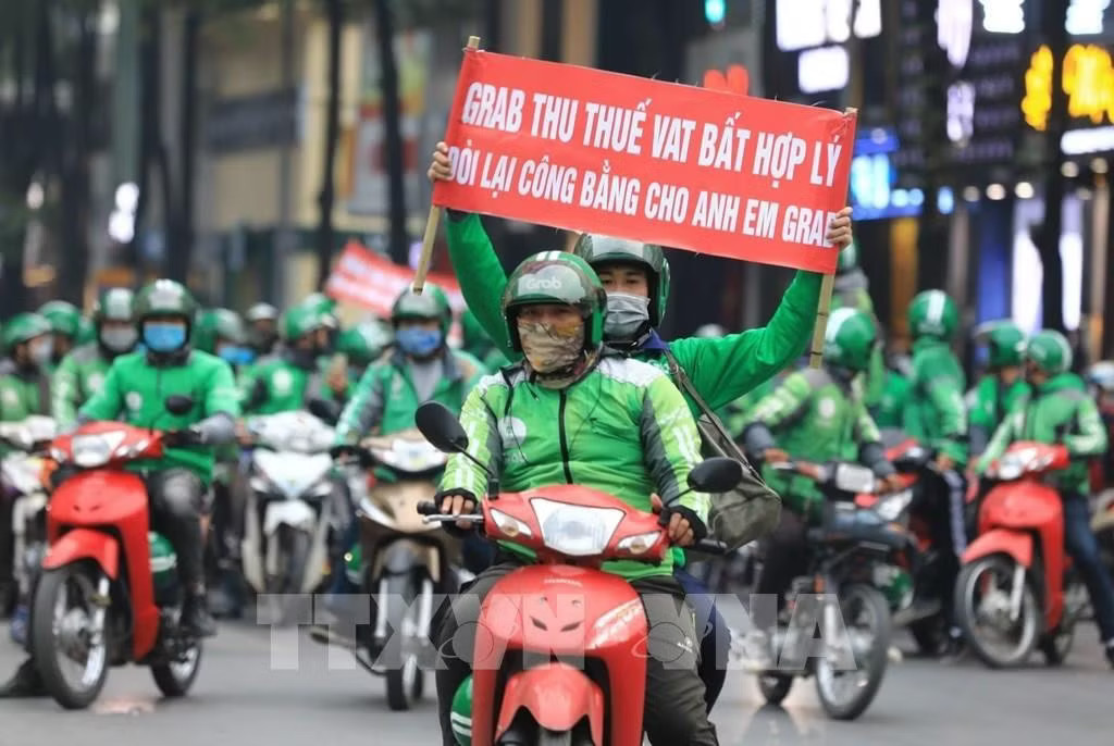 Tài xế từng phản đối chính sách thuế VAT bất hợp lý của Grab. Ảnh: TTXVN. Lùm xùm phí Grab cao, cần siết lại ‘luật chơi’? - Ảnh 1.