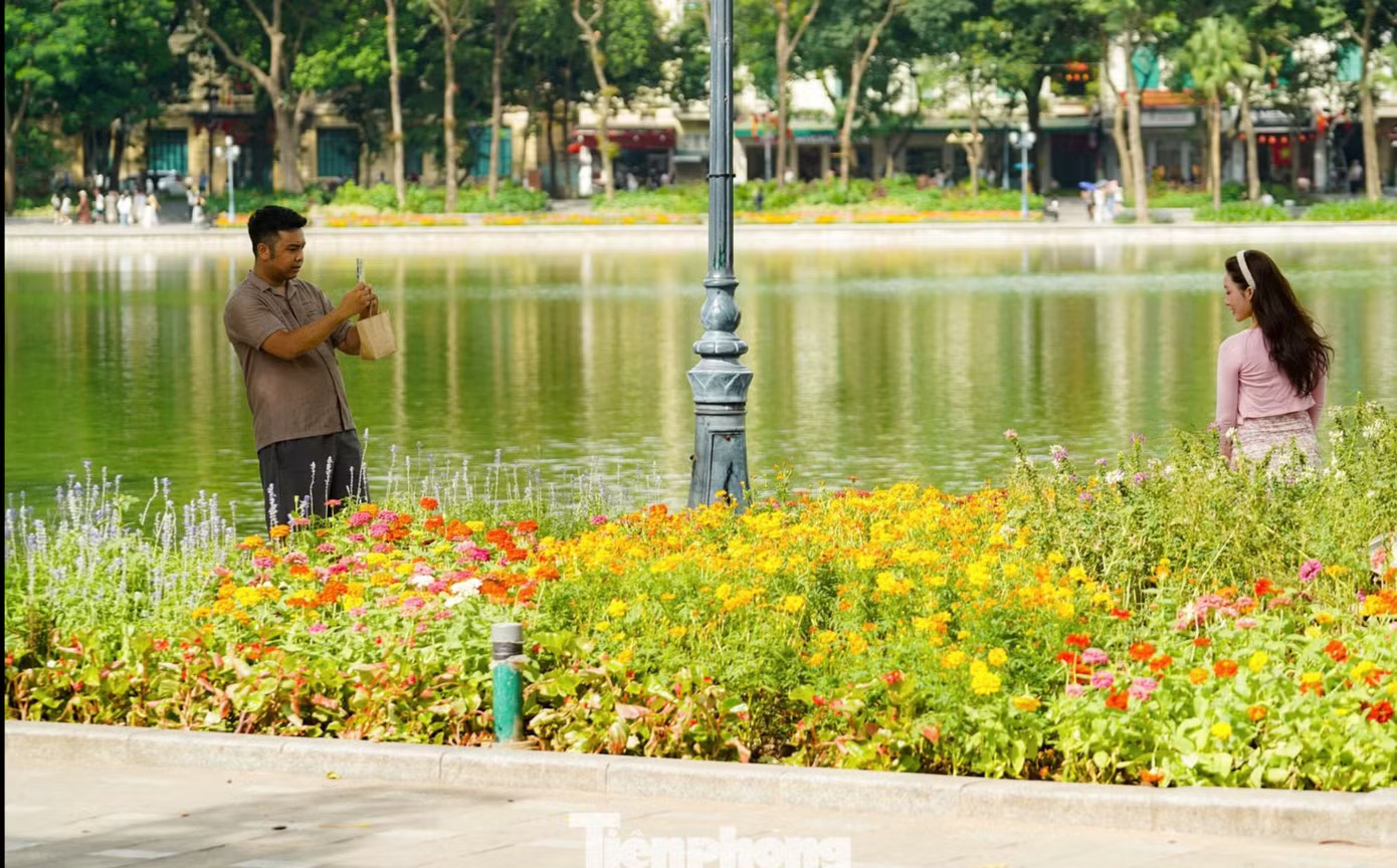 Các cặp đôi tranh thủ ghi lại những khoảnh khắc đẹp ở Hà Nội. (Ảnh: Tiền Phong) Bộ Nội vụ nói về đề xuất giảm thời giờ làm việc xuống 44 hoặc 40 giờ/tuần - Ảnh 2.