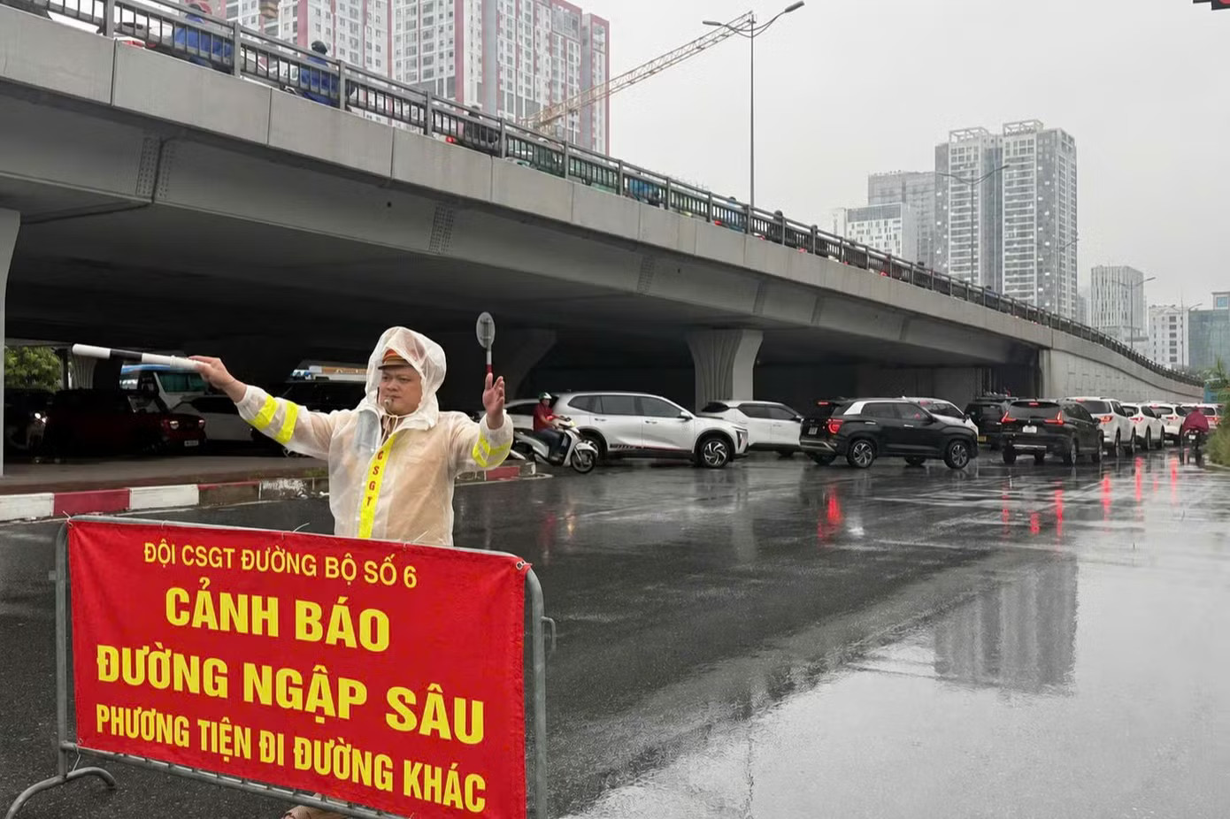 Đội CSGT đường bộ số 6 đặt biển cảnh báo, hướng dẫn phương tiện di chuyển qua khu vực nước ngập. Hà Nội: CSGT phân luồng, khuyến cáo người dân di chuyển qua khu vực ngập nước - Ảnh 2.