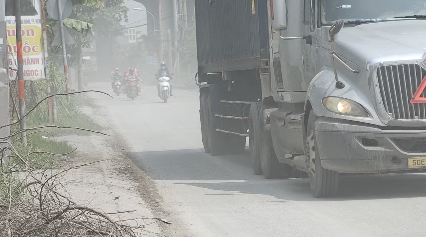 Khi trời nắng thì bụi bay mù mịt mỗi khi các phương tiện trọng tải lớn chạy qua. Ảnh: Khoa Nam. Ám ảnh con đường tử thần ở TPHCM, mới vá xong lại nát bét - Ảnh 8.