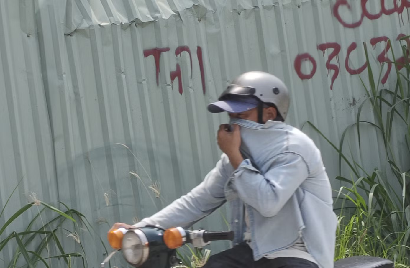 Người đi đường phải bịt mũi để tránh bụi mỗi khi chạy trên đường. Ảnh: Khoa Nam. Ám ảnh con đường tử thần ở TPHCM, mới vá xong lại nát bét - Ảnh 10.