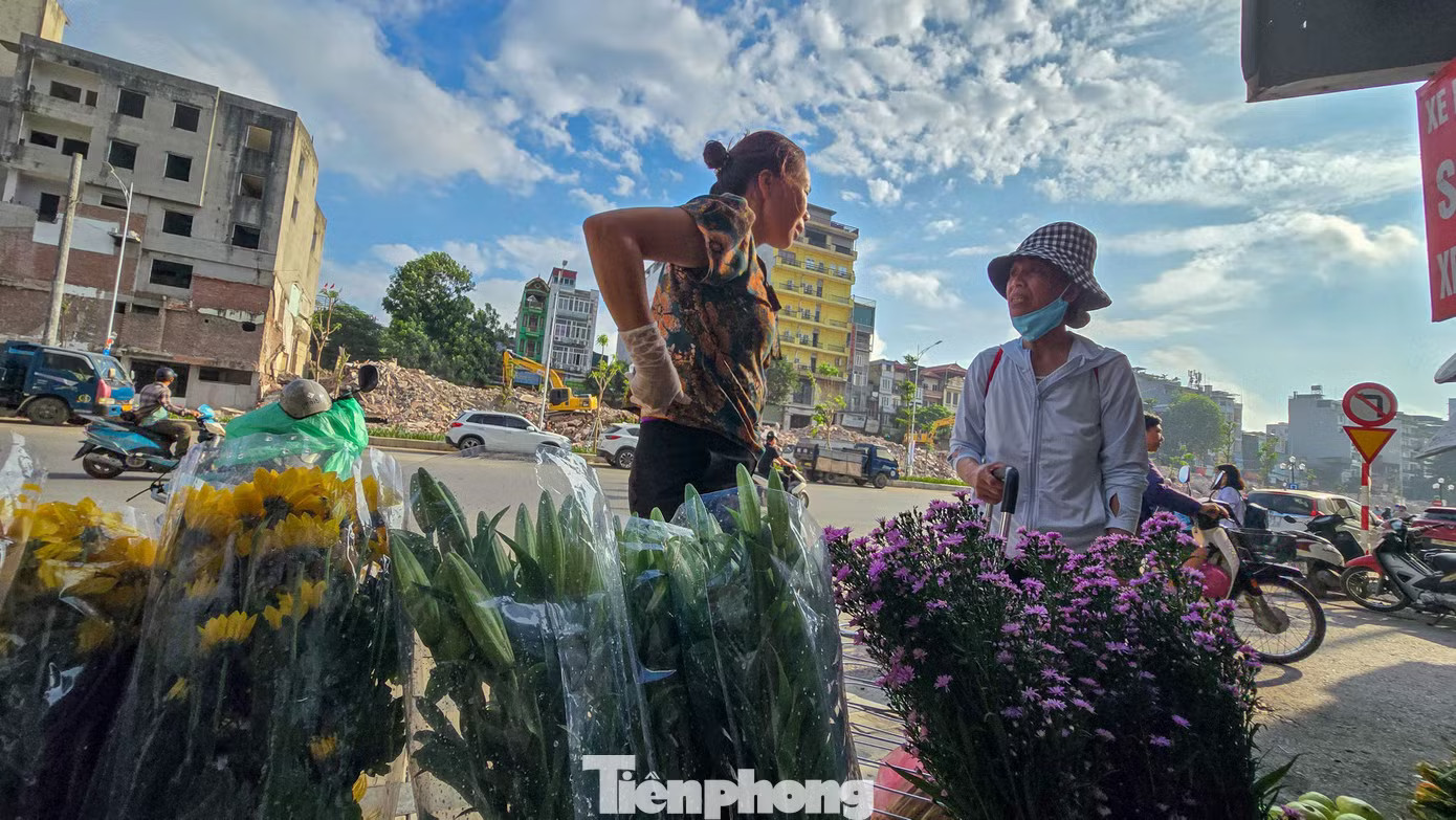 Một tiểu thương thuê vị trí bán hoa, quả tươi với giá hơn 3 triệu đồng mỗi tháng. Điểm bán mới hoạt động vài ngày nhưng lượng khách còn thấp. Hàng quán mở cửa trở lại trên tuyến Hoàng Cầu - Voi Phục mới - Ảnh 6.