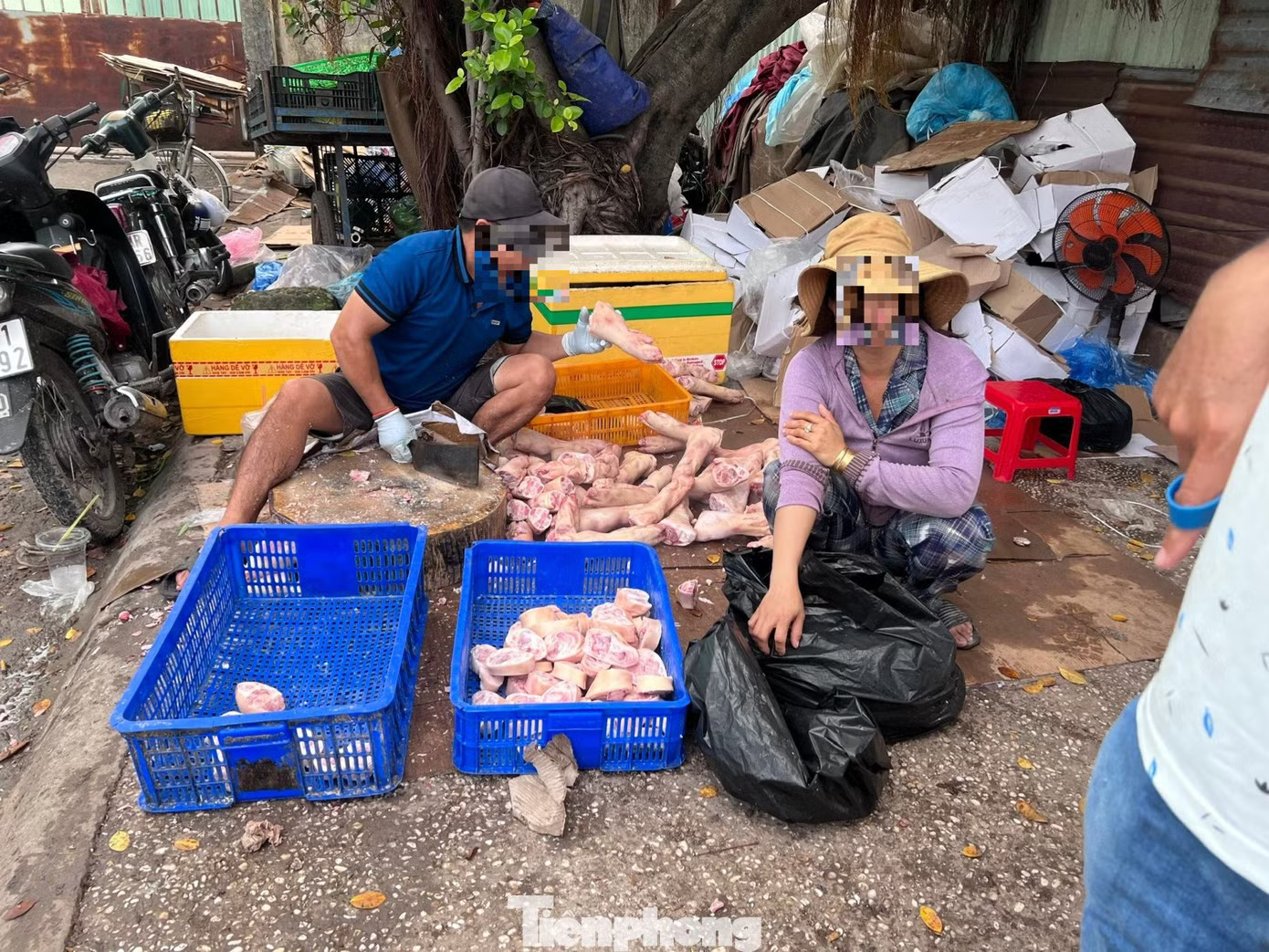 Thịt heo đông lạnh đổ đống trên vỉa hè bên hông chợ đầu mối Hóc Môn, chân giò heo được người bán chặt thành từng khúc nhỏ Thịt đông lạnh nhập khẩu: Mua càng nhiều, giá càng rẻ - Ảnh 1.