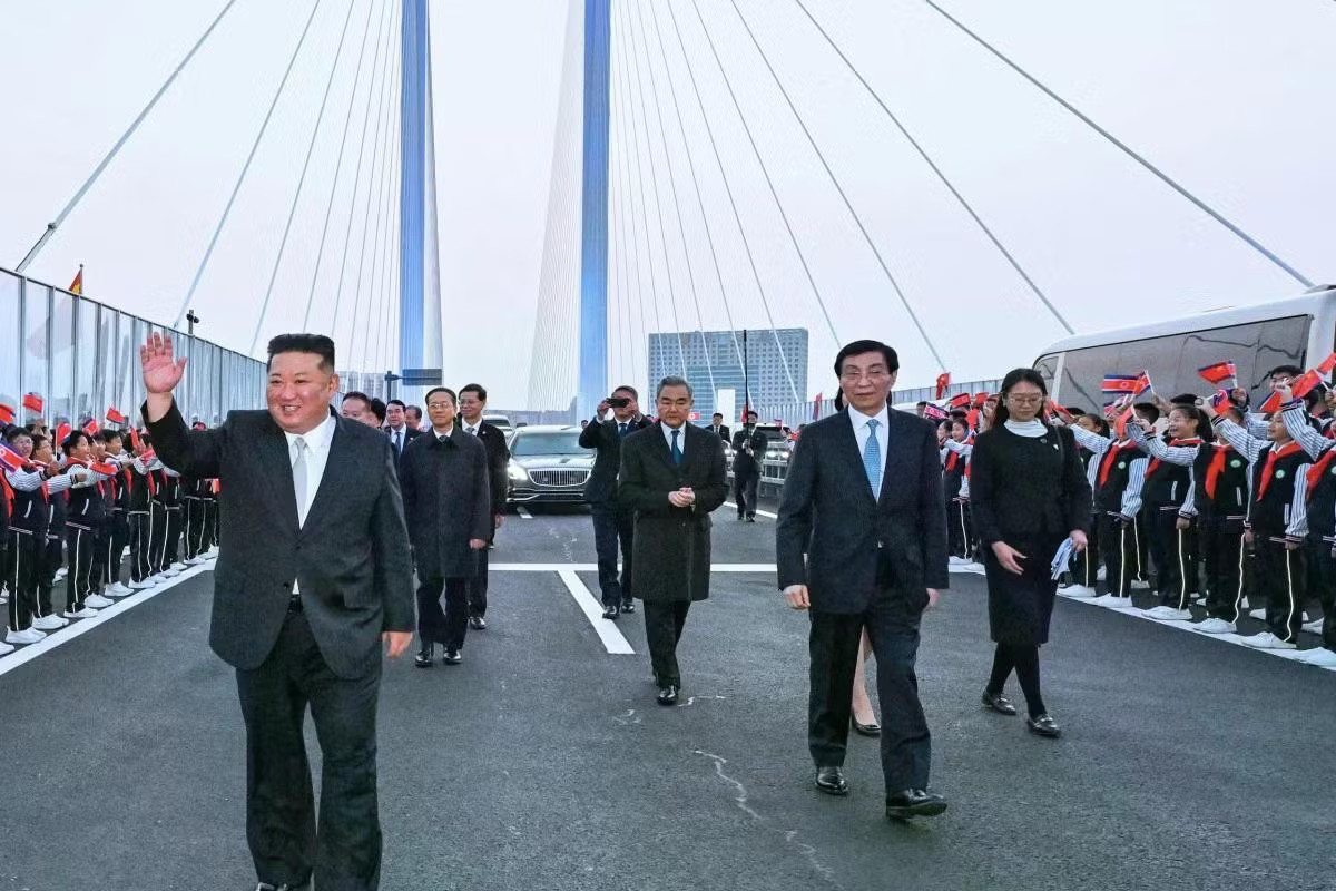 Ông Vương Hộ Ninh (thứ hai từ phải sang) và ông Vương Nghị (thứ ba từ phải sang) tiễn ông Kim Jong-un tại cây cầu bắc qua sông Áp Lục. (Ảnh: Tân Hoa Xã) Trung Quốc đăng ảnh chuyến thăm chớp nhoáng của Chủ tịch Triều Tiên Kim Jong-un - Ảnh 3.