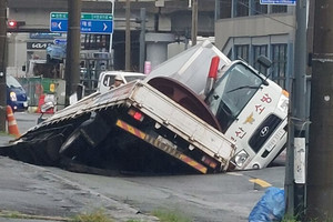 Xuất hiện 'hố tử thần’ khổng lồ sâu 8m nuốt chửng 2 xe tải sau mưa lớn, cảnh sát khẩn cấp phong tỏa hiện trường