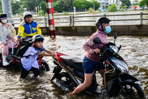 Triều cường lên đỉnh, người dân chật vật lội nước về nhà, nấu cơm bằng bếp dầu