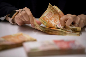 Trung tâm tài chính hàng đầu châu Á mua vào lượng USD kỷ lục để bảo vệ chế độ neo tỷ giá