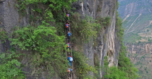 Ngôi làng trăm năm tuổi nằm cheo leo trên vách núi, phải leo hơn 2.500 bậc mới tới nơi, trẻ "đu" cầu thang chênh vênh khiến báo quốc tế ngỡ ngàng